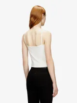 Top de mujer Diesel modelo T-Hupy-Od, de calce ajustado y confeccionado en tejido de punto acanalado blanco. Presenta tirantes finos, escote redondo y el logo ovalado metálico de la marca en el centro del pecho.