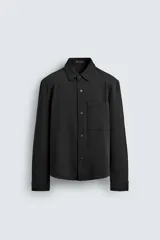 Sobrecamisa regular fit de color negro, confeccionada en tejido transpirable y elástico. Presenta cuello solapa, cierre frontal con botones a presión, manga larga con puños abotonados y un bolsillo de plastrón en el pecho.