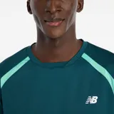 Remera deportiva New Balance de tenis, color verde petróleo con detalles en verde claro en los hombros. Presenta cuello redondo, mangas raglán con paneles de malla transpirable y logo de la marca estampado en el pecho.