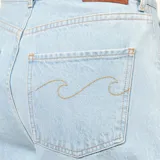 Pantalón de jean estilo baggy wide leg, color celeste claro con efecto desgastado. Presenta cinco bolsillos, cierre frontal con botón metálico y detalle de bordado de ola en los bolsillos traseros.