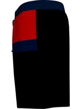 Short de baño largo Tommy Hilfiger, con cintura elástica ajustable con cordón, bolsillos laterales y estampado con bloques de color blanco, rojo, azul y negro.
