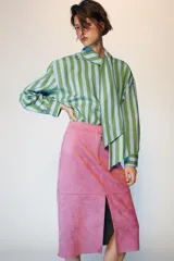 Camisa de rayas rojas y celestes, con cuello subido y lazada en el mismo tejido, manga larga con puños y bajo asimétrico.