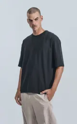 Remera negra de algodón premium, corte crop y oversize, con hombros caídos y cuello redondo.