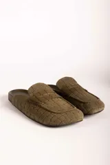 Zueco tipo mocasín destalonado en color verde oliva, con textura grabada efecto cocodrilo y acabado en gamuza.