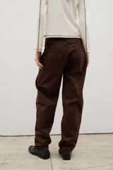 Pantalón de gabardina con corte barrel, diseño holgado y tiro medio. Cuenta con cierre frontal y bolsillos laterales.