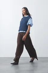 Chaleco de punto con textura afelpada, cuello redondo y hombros marcados. Presenta una silueta relajada y un diseño sin mangas.