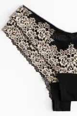 Pack de dos bombachas tipo brazilian de tiro bajo, confeccionadas en encaje floral color beige y malla negra, con cintura en V y refuerzo interior.