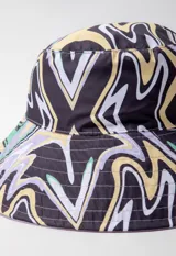 Gorro tipo bucket hat estampado con flores y hojas en tonos verde y celeste sobre fondo blanco. Es reversible.