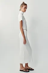 Falda midi tubo de punto color blanco, de corte recto y cintura elástica.