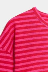 Remera de manga larga con diseño de rayas horizontales en tonos fucsia y rosado, cuello redondo y corte holgado.