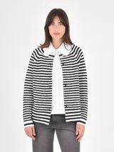 Buzo de punto a rayas horizontales blancas y negras, con cuello camisero blanco con volados y cierre frontal de botones.