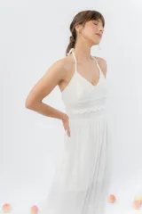 Vestido largo negro con top tejido en crochet y falda de gasa liviana con caída natural. Escote halter con breteles que atan al cuello y detalle de puntilla en la unión del busto.