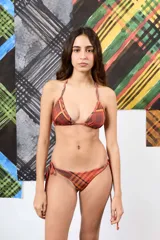 Top de bikini triangular con estampado a cuadros en tonos marrón, celeste y verde, con un aplique floral tridimensional de cuentas verdes en el tirante.