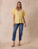 Remera blanca de lino con mangas cortas y fruncido en los hombros.