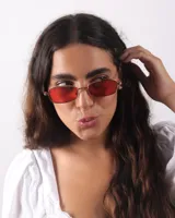 Lentes de sol rectangulares con marco metálico color bronce y cristales rojos.