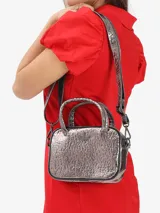 Bolso compacto Adidas de diseño funcional con acabado metalizado texturizado. Cuenta con cierre de cremallera, manijas superiores, correa ajustable y desmontable, y el logo del trébol distintivo en el frente.