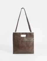 Sobre plegable de cuero vegano con diseño minimalista y abertura superior integrada. Incluye correa removible para usar como bandolera.