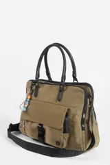 Briefcase negro de nylon con tres compartimentos, dos con cierre, bolsillo delantero con solapa y cierre de broche a presión. Cuenta con doble asa de mano, correa regulable y un llavero decorativo con cuentas coloridas colgando de uno de los herrajes.