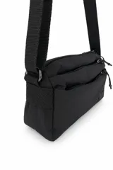 Cartera tipo bandolera de color negro, con diseño funcional de múltiples compartimentos con cierre y correa ajustable. Incluye detalle de etiqueta con logo de la marca en el frente.