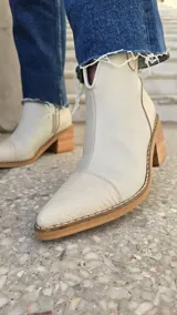 Botas cortas de cuero color blanco marfil con punta fina texturizada estilo reptil y taco cuadrado de madera de 6 cm.