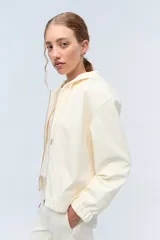 Campera deportiva con capucha confeccionada en tela elastizada texturada con diseño de flores.