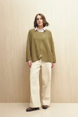 Sweater color beige de tejido de punto con cruce irregular y botones a contraste.