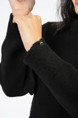 Sweater de punto en color beige, con cuello redondo y diseño de calce relajado. Presenta puños y ruedo acanalados.