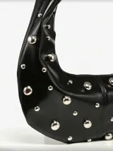 Bolso hobo de cuero sintético color bordó, con tachas plateadas.