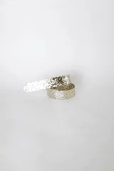 Cinturón de cuero liso, color plateado metálico, con diseño de lazo simple sin costuras ni agujeros.