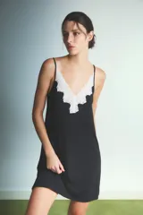 Camisón corto de color negro con breteles finos y detalle de encaje blanco en el escote en V.