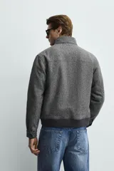 Cazadora relaxed fit de mezcla de lana color gris oscuro, con cuello subido, bolsillos delanteros con solapa, cierre frontal de cremallera y bajo acabado en rib.