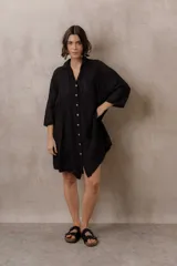 Camisola blanca de silueta amplia y caída liviana, con diseño clásico de cuello camisero, cierre frontal con botones y mangas tres cuartos, decorada con grandes motivos florales bordados.