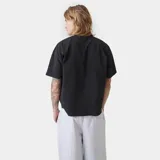 Remera de corte boxy fit color negro, con estampado gráfico frontal que incluye escudos y tipografía en color blanco.