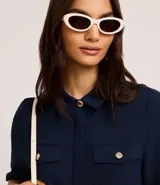 Camisa color fucsia de tejido airflow, con cuello camisero, mangas cortas con pliegues, cierre frontal con botones metalizados y bolsillos con solapa en el pecho.