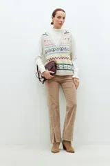 Chaleco de punto beige con jacquard multicolor, escote en V y corte recto.