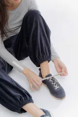 Pantalon de corte holgado y estilo bombacho, confeccionado en tela suave con ligero brillo. Presenta cintura elastizada en la parte trasera y puños elásticos en los tobillos que definen su silueta.