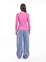 Remera negra de manga larga con cuello redondo y detalle de pequeñas tachas plateadas alrededor del cuello.