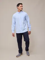 Camisa de manga larga para hombre, confeccionada en algodón con efecto peach (textura suave). Presenta un estampado de cuadros vichy en tonos azul marino y blanco, cuello con botones y un bolsillo de parche en el pecho izquierdo.