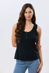 Musculosa lisa de algodón color negro, con cuello redondo, cierre frontal parcial con botones y detalle de volados en los breteles.