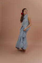 Pollera larga de lino color gris topo, de diseño amplio con volumen, movimiento y bolsillos delanteros. Cuenta con elástico en la cintura y detalles de pinzas y sobretelas en los laterales.