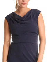 Vestido corto sin mangas con cuello volcado y detalle de drapeado horizontal en la cintura. Confeccionado en tejido con acabado brillante tipo lurex, presenta un corte ajustado que estiliza la figura.