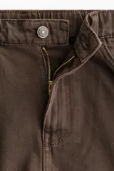 Short de cinco bolsillos en denim de algodón rígido, de tiro alto con cierre y botón, corte holgado y bajo deshilachado.