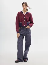 Pantalón jean de tiro alto y corte pinzado, con perneras de caída suelta y levemente anchas en el bajo. Posee pasador con hebilla en la parte trasera.