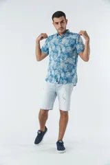 Camisa de manga corta con estampado botánico de hojas en tonos azul y blanco. Presenta cuello clásico, cierre frontal abotonado y corte slim.