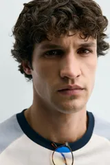 Camiseta de hombre regular fit, color blanco con mangas raglán cortas en azul claro y cuello redondo en rib azul marino.