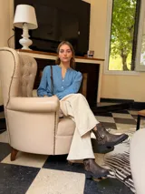 Bota corta de cuero vacuno en color chocolate con efecto desgastado. Presenta una suela track de goma negra, detalle de pulsera desmontable con tachas metálicas y cierre lateral.