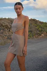 Vestido corto color gris, confeccionado en lino y rayón, con escote recto, breteles regulables y espalda con tiras regulables.