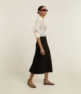Pollera larga de corte evasé con estilo slip, confeccionada en tejido de cupro con cintura de sastrería. Presenta un diseño liso y fluido que se ajusta en la cintura y se abre ligeramente hacia el ruedo.