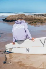 Hoodie de corte oversize color lila, con capucha ajustable mediante cordones, bolsillo frontal tipo canguro y bordado sutil en el pecho.