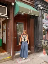 Falda larga negra con diseño de caderín y tablas.